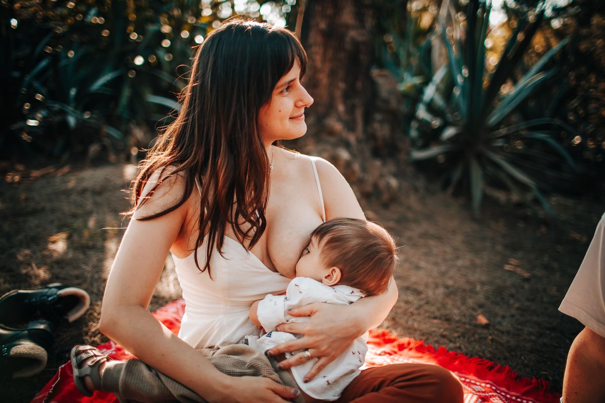 Mãe amamentando e alimentando o bebê durante a fase de introdução alimentar