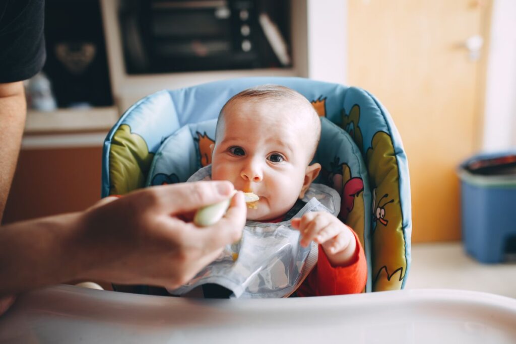 Bebê sendo alimentado com boa postura em cadeirão